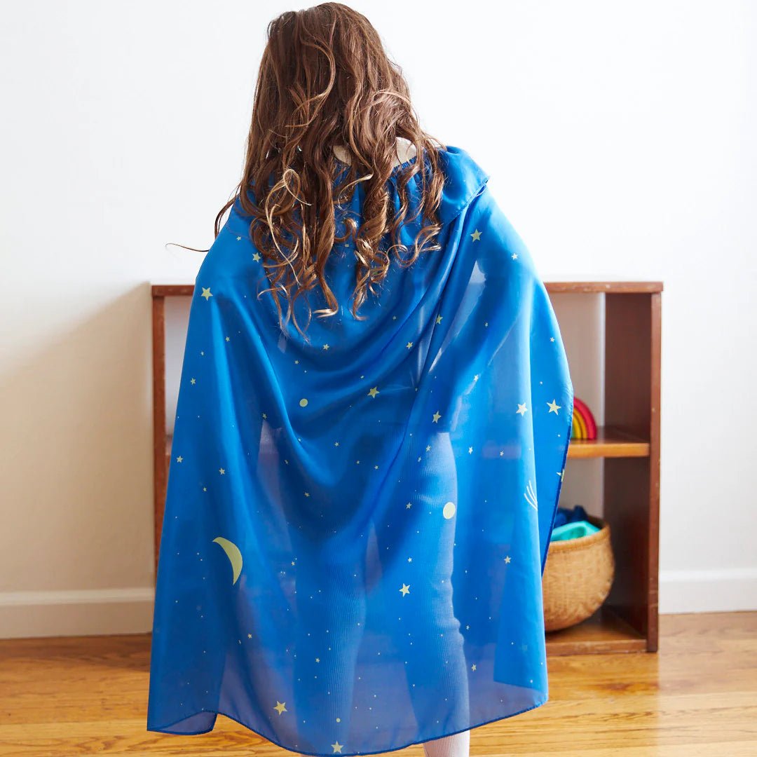 Back view of a child wearing a blue and yellow starry night cape