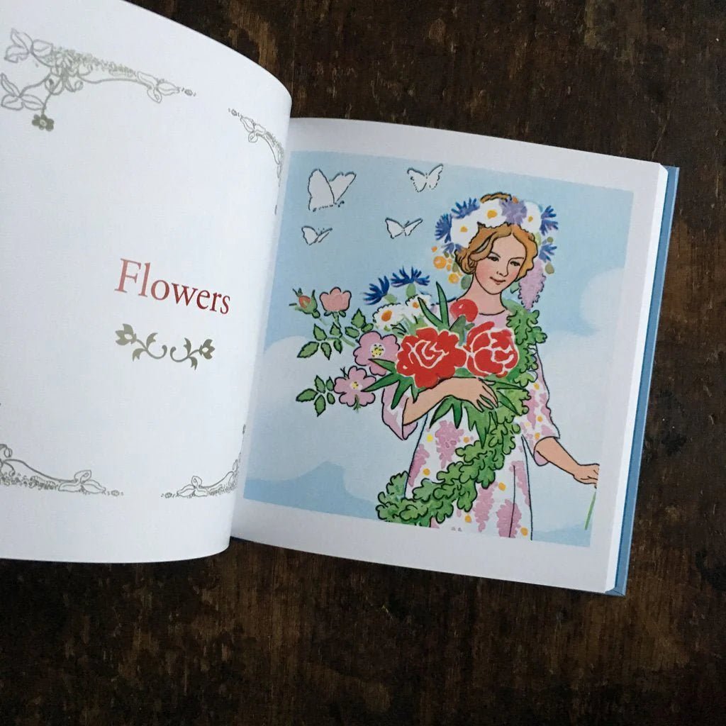 Elsa Beskow Alphabet Book open to the page "Flowers" with a woman holding a bouquet of flowers and wearing a flower crown
