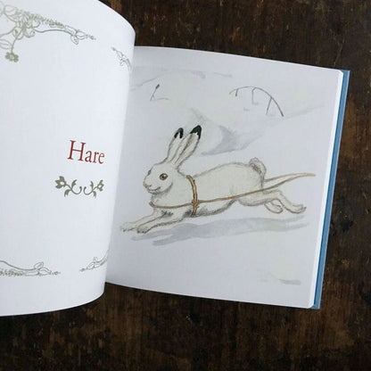 Elsa Beskow Alphabet Book open to the page "Hare" with a white hare running through the snow