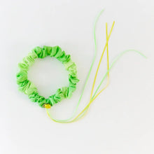 Green silk garland with yellow rose and ribbons on a white background