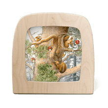 Wooden frame with silhouette of children and squirrels playing in a tree on a white background