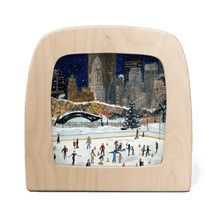 Wooden frame with silhouette of a New York cityscape in winter with people ice skating below