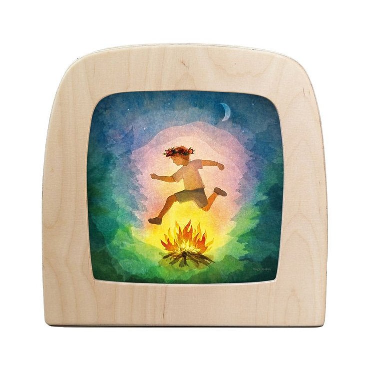 Silhouette of a child jumping over a fire in the forest