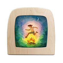 Silhouette of a child jumping over a fire in the forest