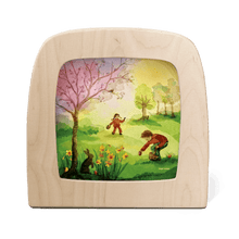 Two children having an Easter egg hunt in a colorful field