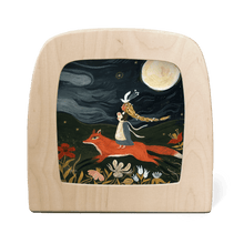 Silhouette of a girl and baby riding on the back of a large orange fox