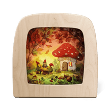 Silhouette of three gnomes sitting at a table outside of their mushroom home enjoying a picnic