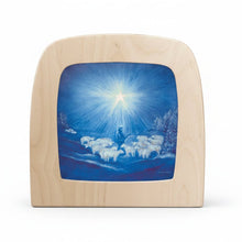 Wooden plaque with a painted scene of a shepherd and sheep under a bright star on a blue sky.