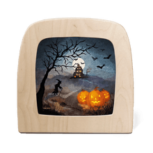 Silhouette of a Halloween scene featuring a witch, bats, and jack-'o-lanterns on a dark background 