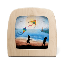 Silhouette of two children flying kites at the beach