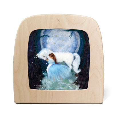 Silhouette of a girl in a blue dress hugging a unicorn with the moon in the background