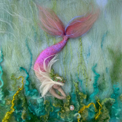 Mermaid with a pink tail lying among underwater plants
