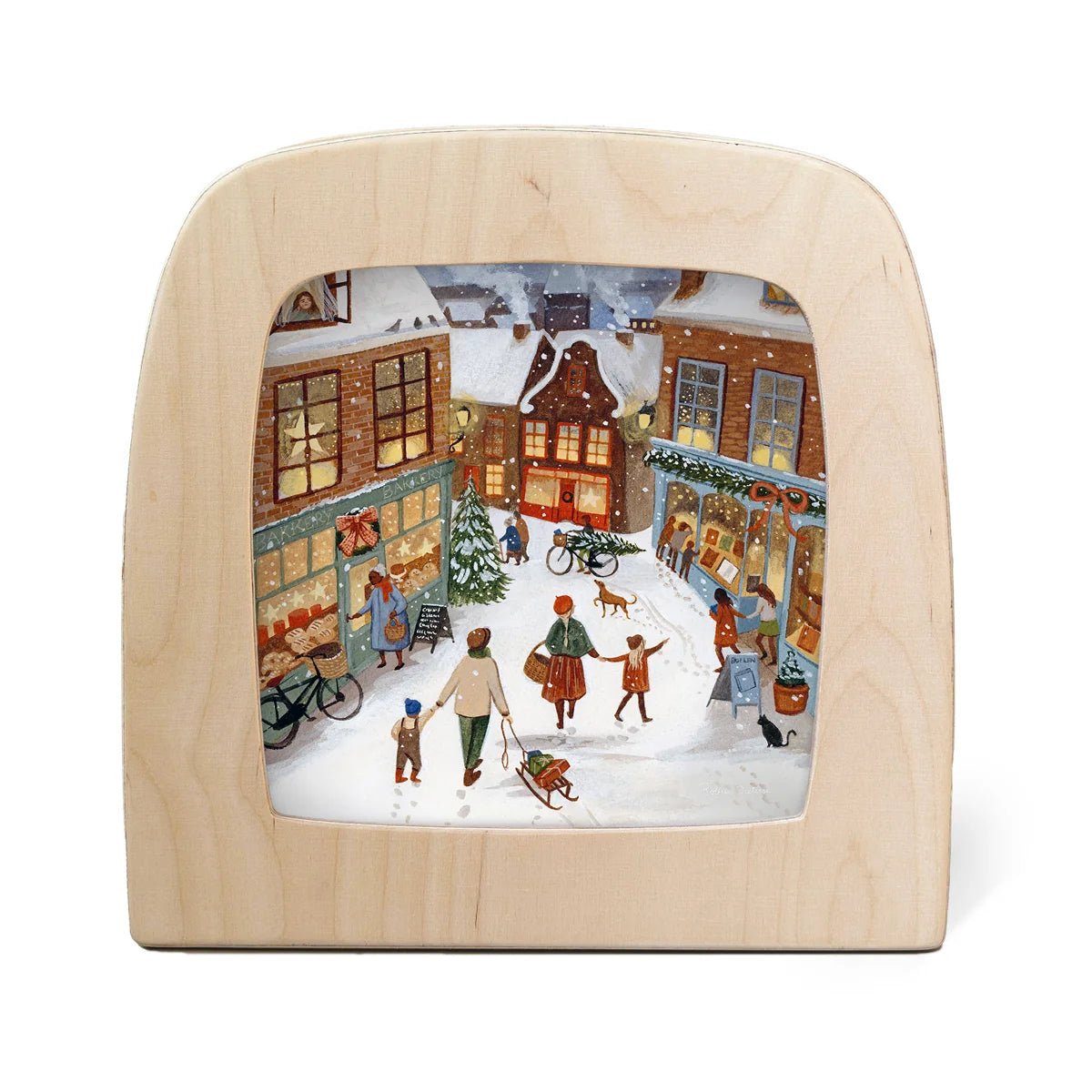 Toverlux lamp featuring a colorful winter village scene printed inside. The light natural wood frame surrounds a detailed illustration of a snowy street with people, houses, bicycles, and storefronts.