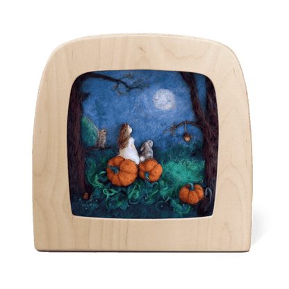 Silhouette of a girl and a rabbit sitting on pumpkins looking at the moon