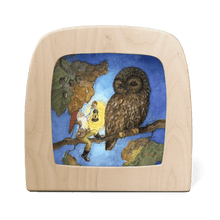 Silhouette of a dwarf holding a lantern sitting next to an owl perched on a branch