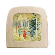 Three children stand in a forest full of yellow, orange, and gold leaves