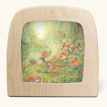 A square wooden picture frame with rounded corners, showcasing a colorful fantasy illustration of a fairy forest with mushrooms and pixies