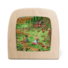 Silhouette of a fall scene of children picking apples with a red cottage in the background