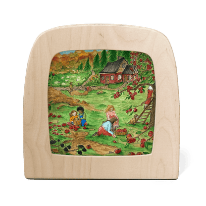 Silhouette of a fall scene of children picking apples with a red cottage in the background