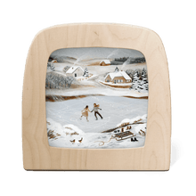 Silhouette of a couple skating on a frozen pond with a snowy landscape in the background
