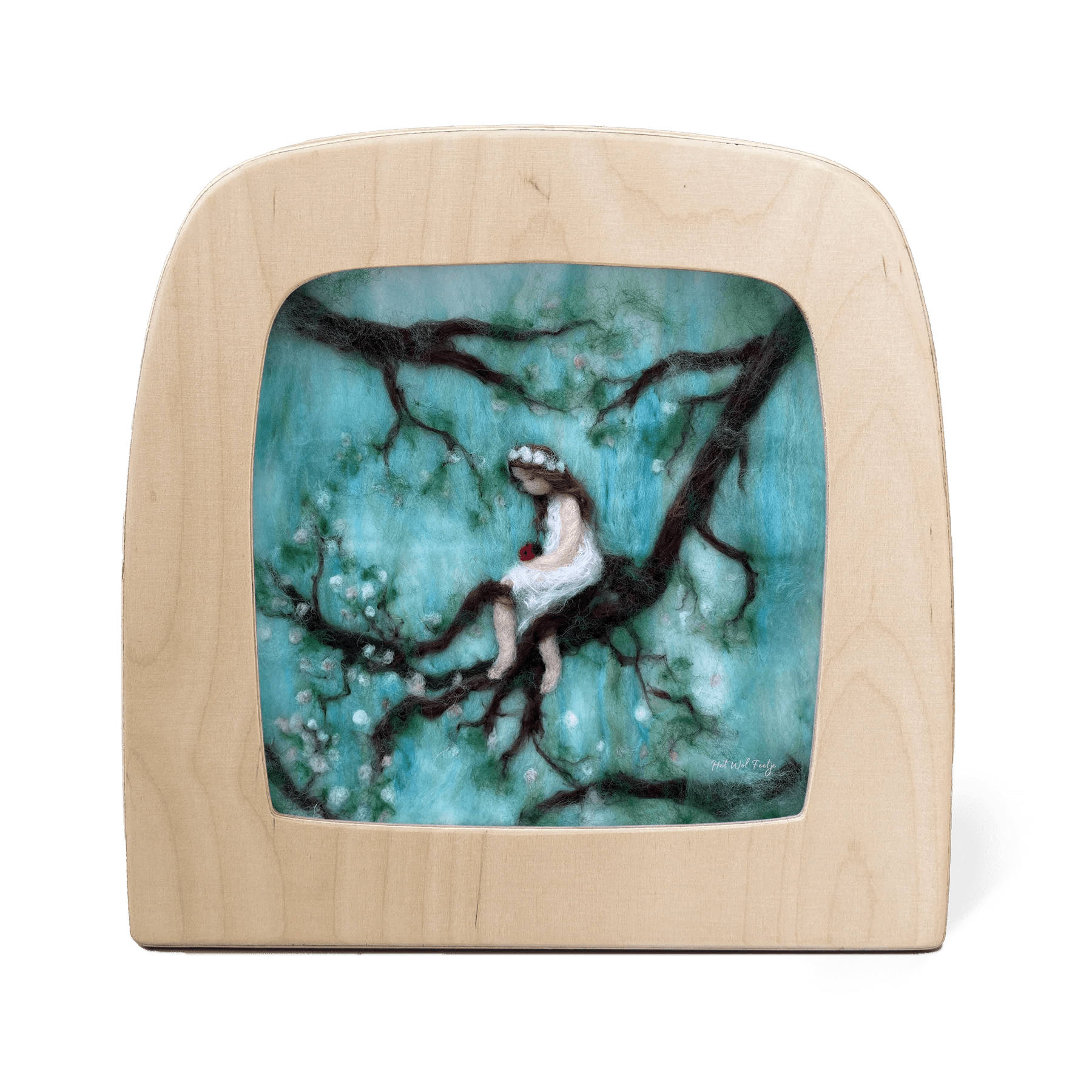 Silhouette with a woman sitting on a branch against a turquoise background, framed by a light wood border.