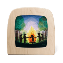 Silhouette of children holding hands around a large bonfire