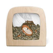 Silhouette of baby sleeping in a basket in a field of flowers and a clothesline