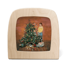 Silhouette of a mother and child decorating a Christmas tree, with presents and a nativity scene at the base