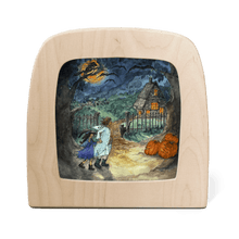 Wooden frame with silhouette of two children trick or treating in the woods