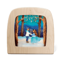 Silhouette of two children holding a candle in a snowy forest
