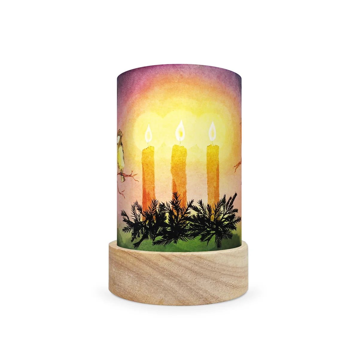 A cylindrical table lamp shade with a printed watercolor-style design of three lit candles above evergreen branches, set on a round natural wood base against a white background.
