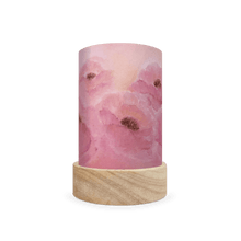 Decorative cylindrical lamp featuring a scene of pink poppies on a white background