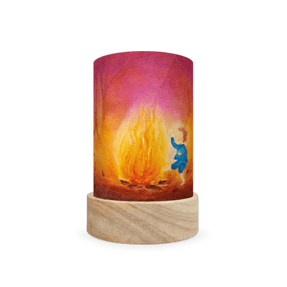 Decorative lamp depicting Rumplestiltskin sitting by a camp fire on a white background