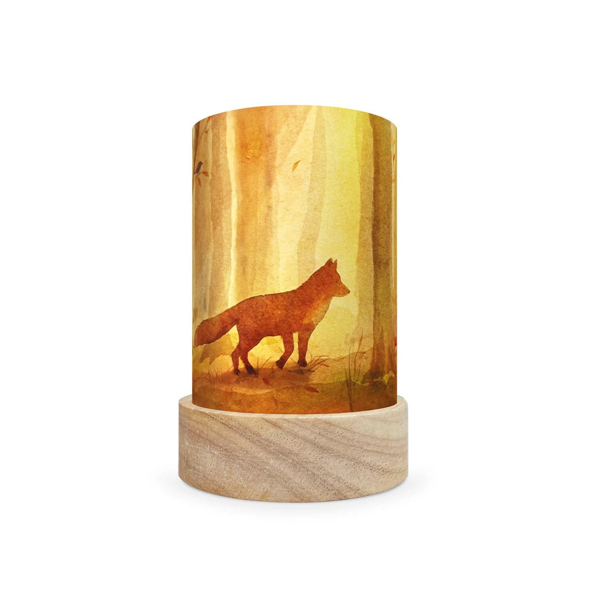 A cylindrical decorative lamp shade with a light natural wood base and a printed wrap-around cylinder featuring a golden-yellow forest scene with a brown fox silhouette, shown on a white background.