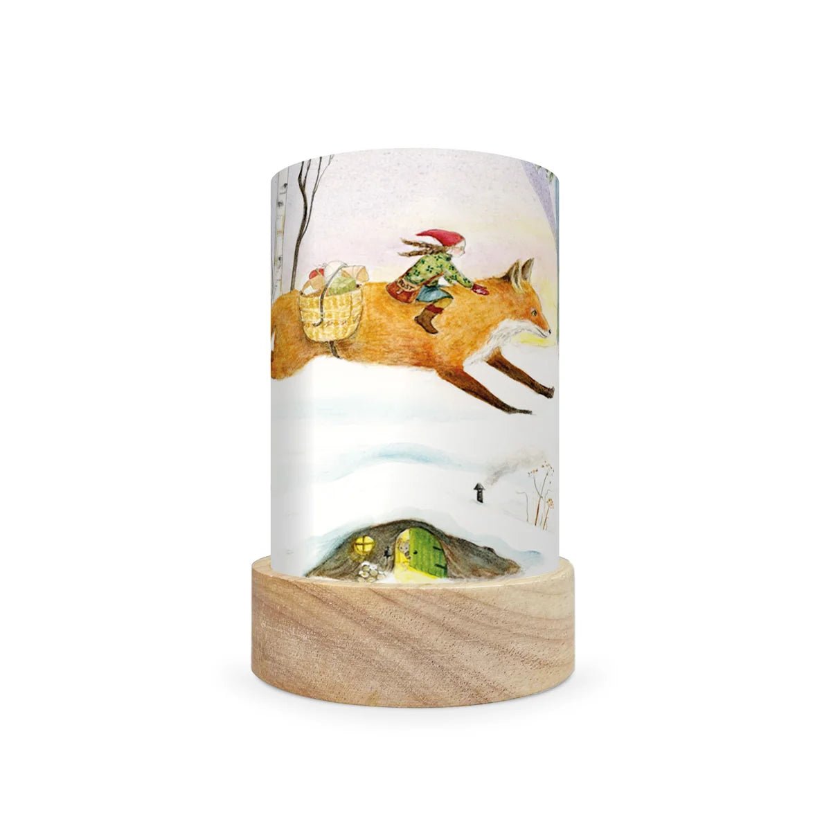 A cylindrical table lamp with a light wood base and a printed wraparound cylinder featuring an illustration of a fox carrying a rider through a snowy landscape, shown on a plain white background.