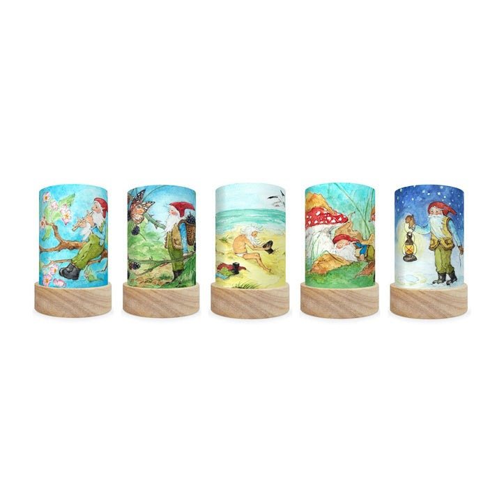 Set of five cylindrical lamps with gnome designs on a white background