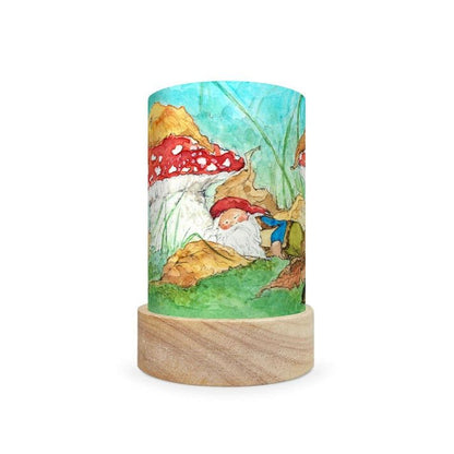 Decorative lamp depicting a scene of a gnome sleeping under a mushroom on a white background