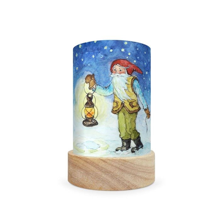 Decorative lamp with a scene depicting a gnome travelling in the snow on a white background