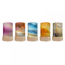 Set of five cylindrical lamps with wooden bases, each featuring a different scenic print.