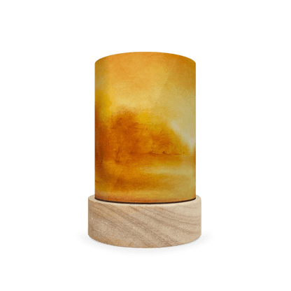 Cylindrical wooden lamp with a yellow to orange gradient landscape of a forest on a white background