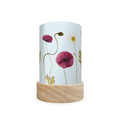 Mini lantern silhouette of pressed purple and white flowers on a light blue background