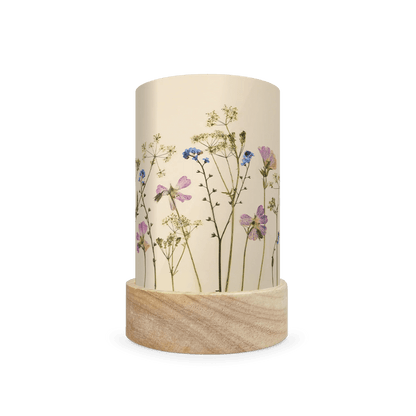 Mini lantern silhouette of pressed pink and blue flowers and bright green leaves on a light background