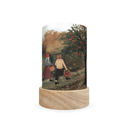 Decorative lamp depicting scene of two people apple picking on a white background