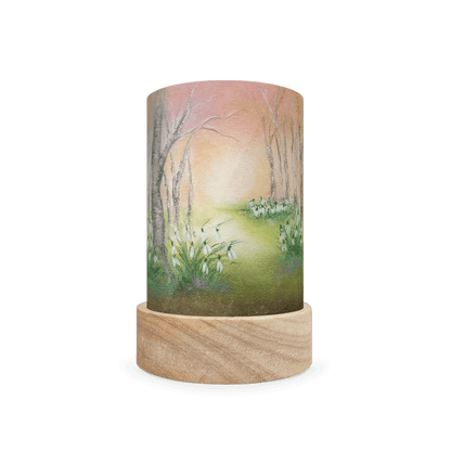 Decorative cylindrical lamp with wintery white flowers and leafless trees on a white background