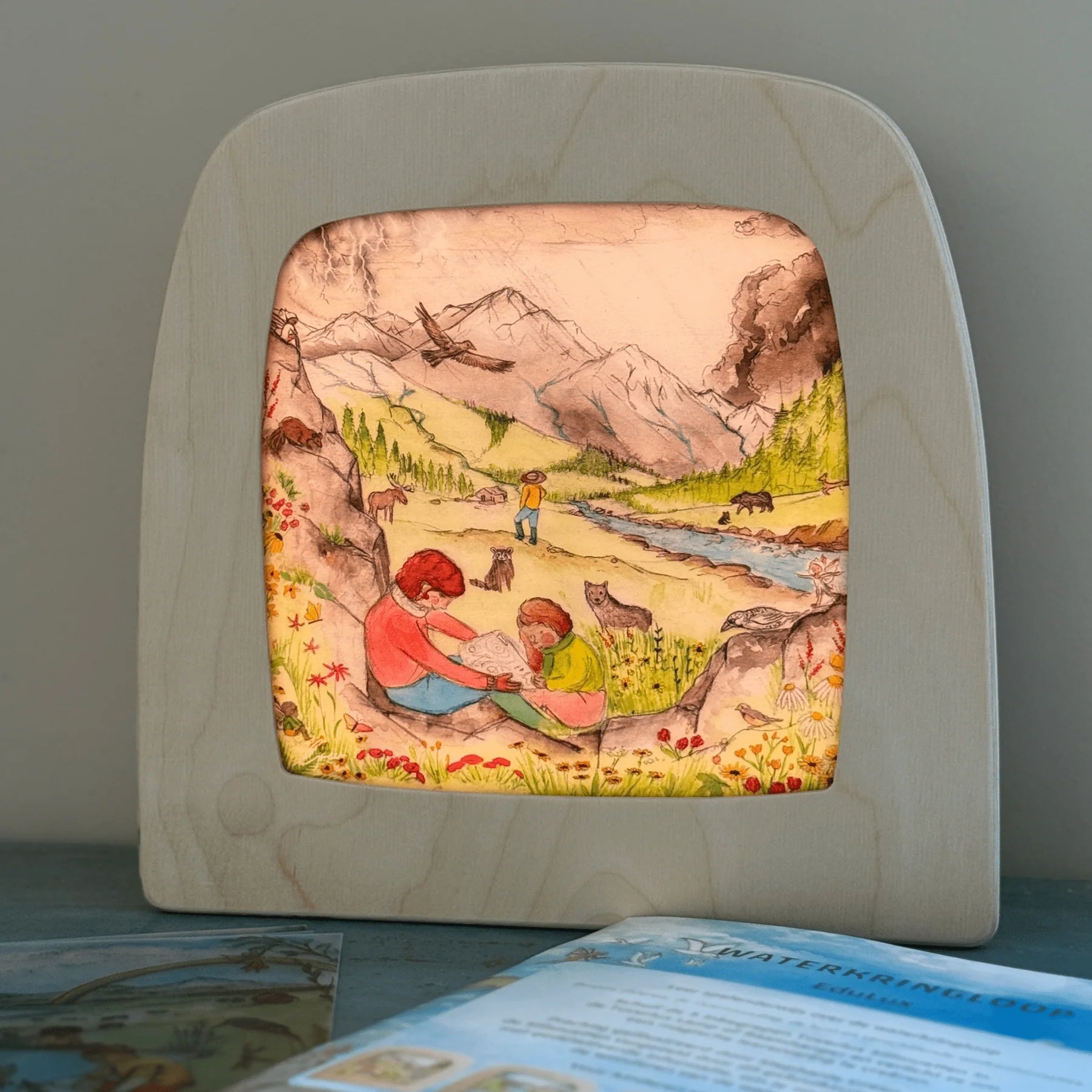 Toverlux silhouette frame with a scene of two children in a mountainous landscape.