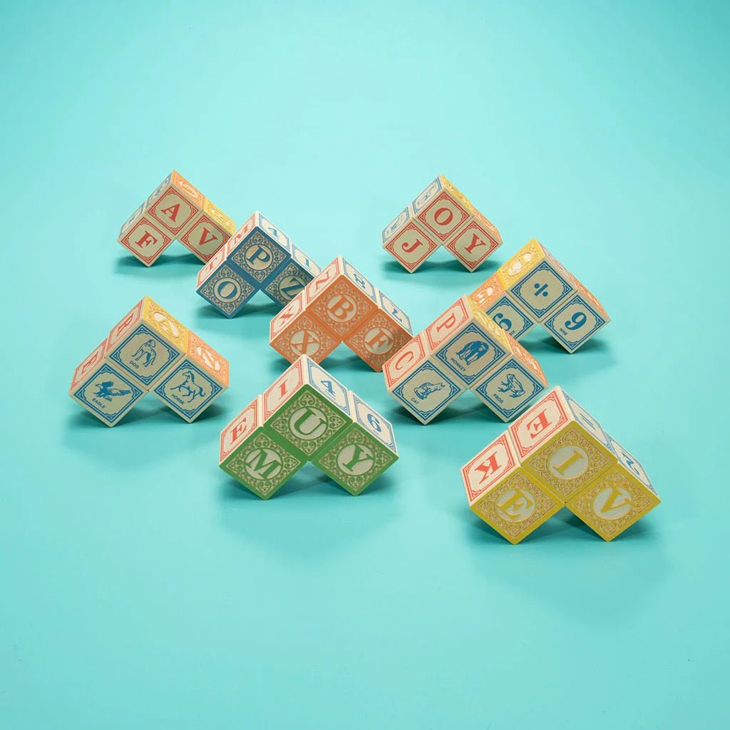 stacks of colorful alphabet blocks on a teal background