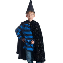 Child wearing a black sparkly cape, hat, and striped shirt on a white background