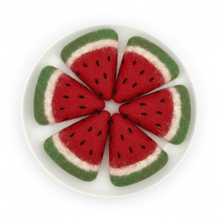 6 slices of felted watermelon on a white plate on a white background