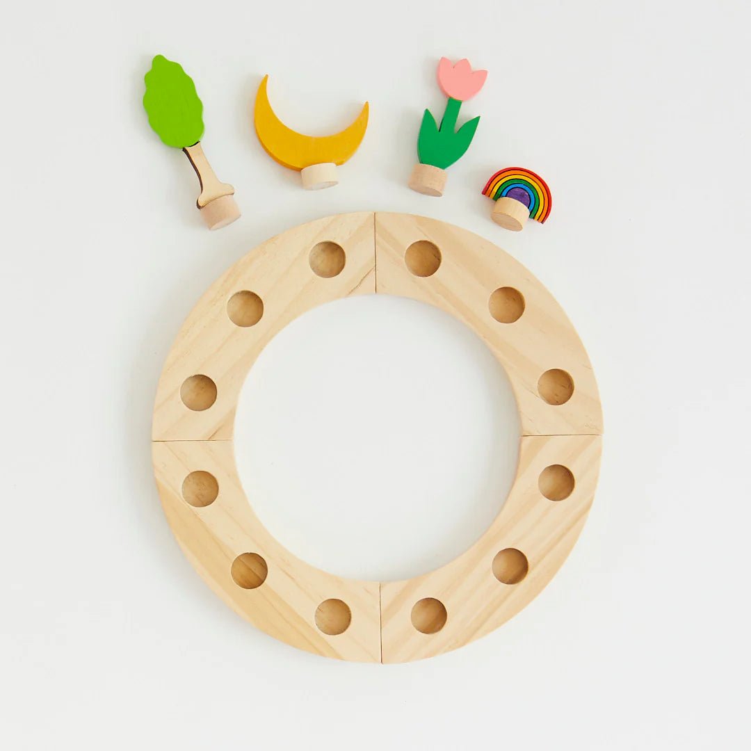 Wooden ring with holes and small colorful wooden figures on a light gray background