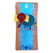 Wooden pin of red, yellow, green, and blue elephant on Nogi branded packaging